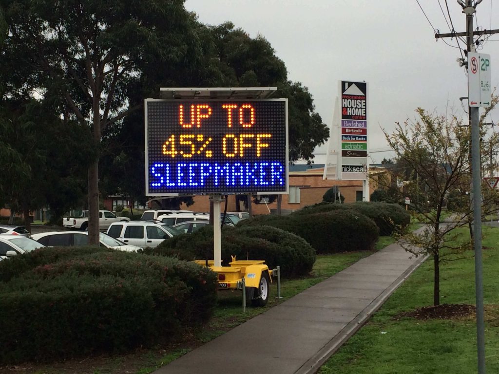Bright 5-colour VMS trailer sign advertising “up to 45% off Sleepmaker” at Snooze in Moorabbin